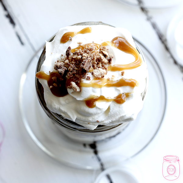 These brownie caramel parfaits are topped with whipped cream and a chocolate crumble.