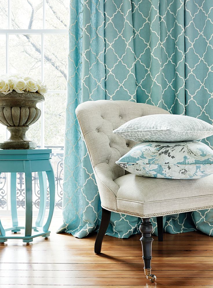 In this living room, we see aqua in the side table, throw pillows and curtains