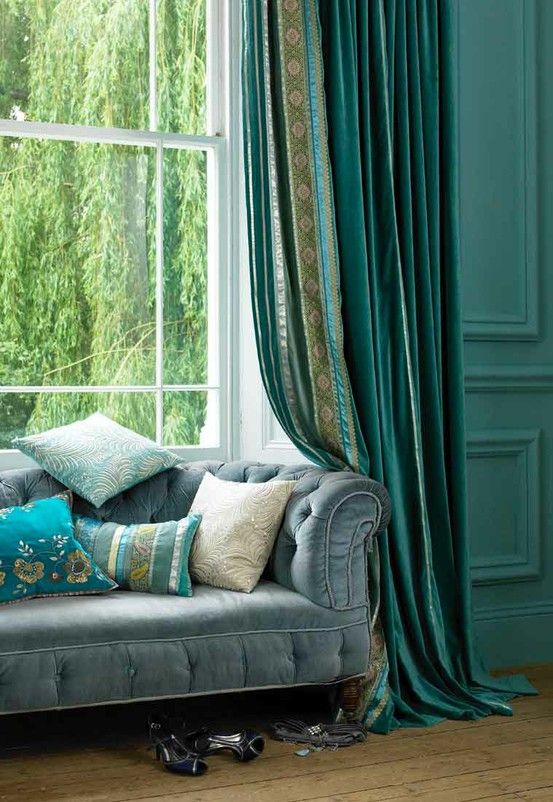 Various shades of blue - from bight aqua throw pillows to deep navy curtains makes a bold statement in this room