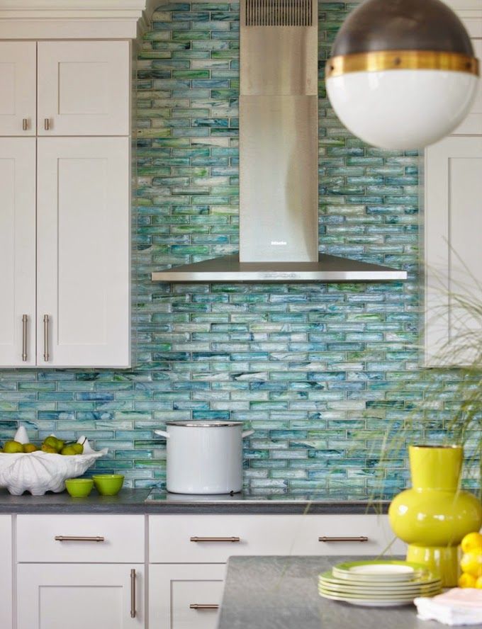 The stunning aqua backsplash in this kitchen adds so much color against the white cabinets