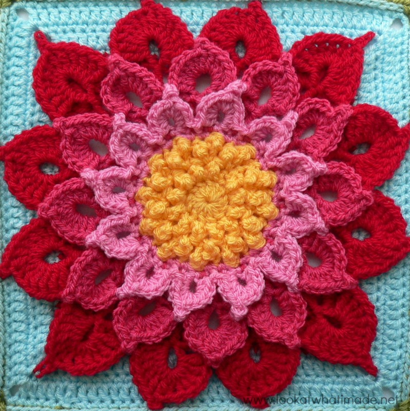 This large crocheted flower with a yellow center and pink petals is so cute. 