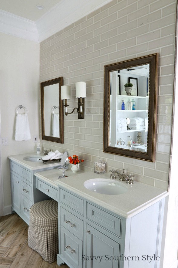 The matching vanity mirrors and light fixtures brighten up this neutral bathroom.