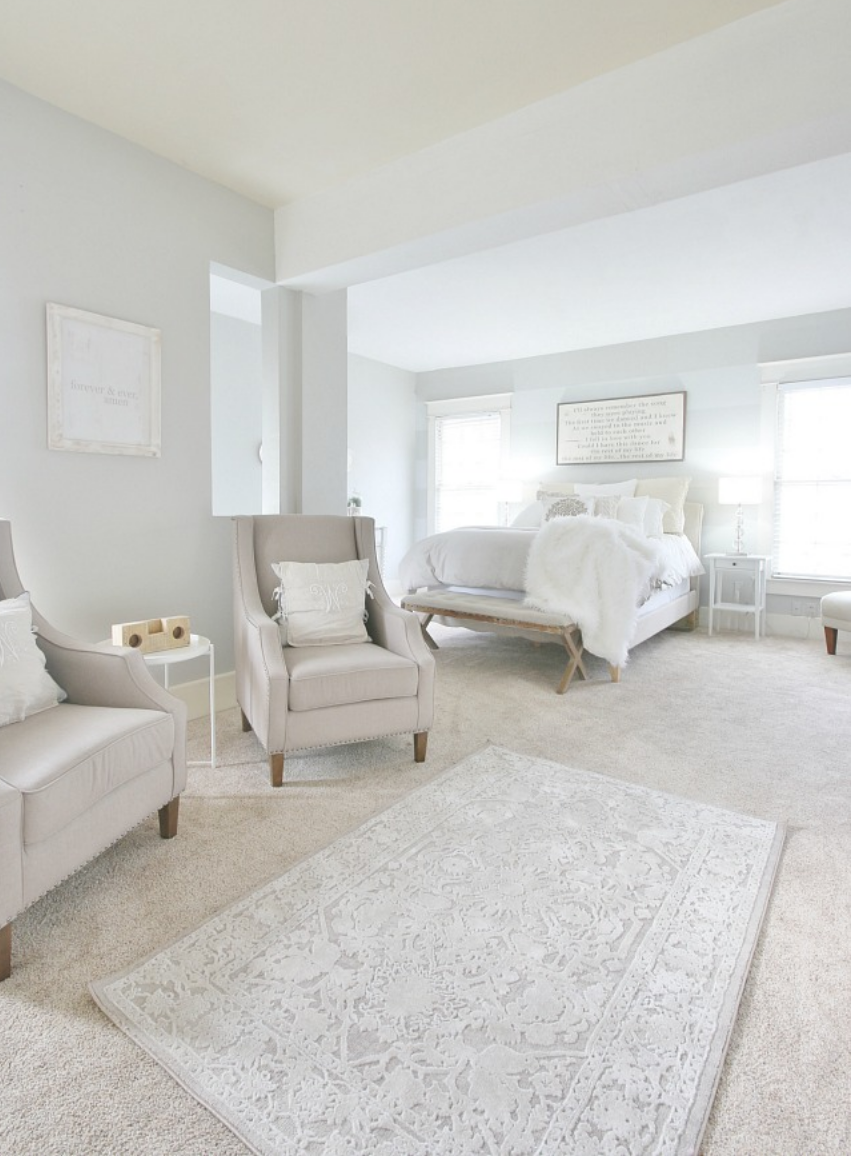 The gray tufted chairs compliment the gray tones in the rug and walls. 