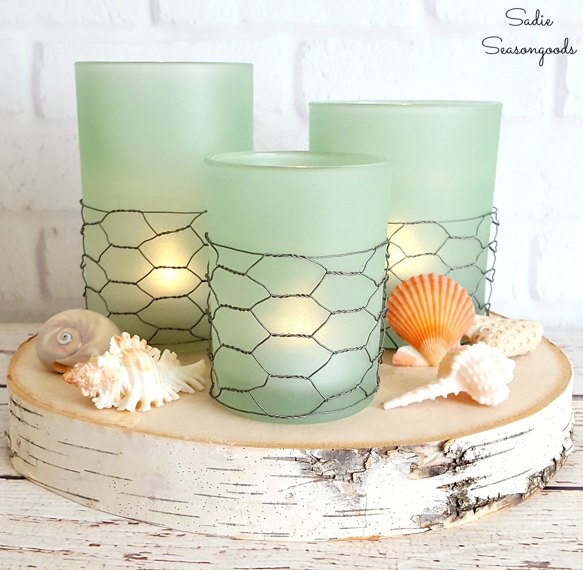 These sea glass candles resting on a piece of wood are coastal and farmhouse chic.
