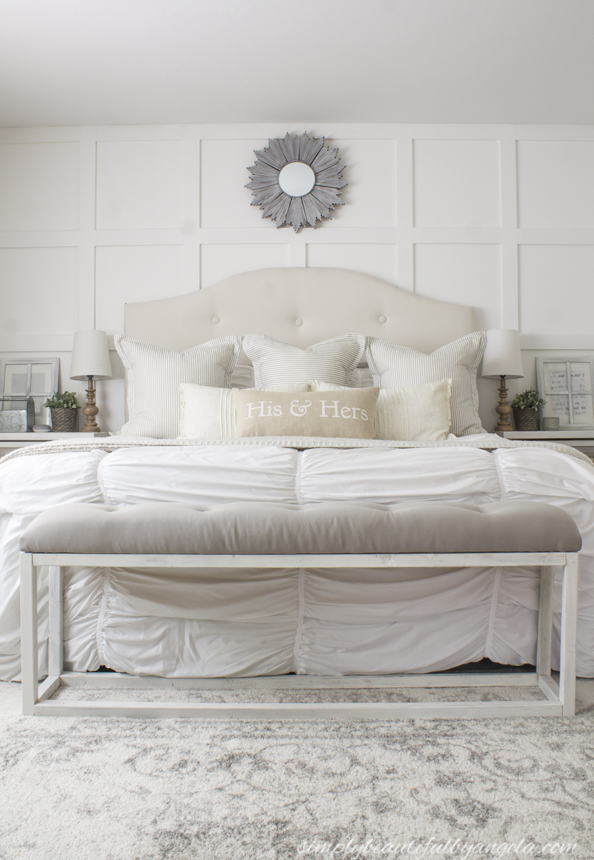 This stunning bedroom has a farmhouse touch with the batten board wall and soft fabric headboard