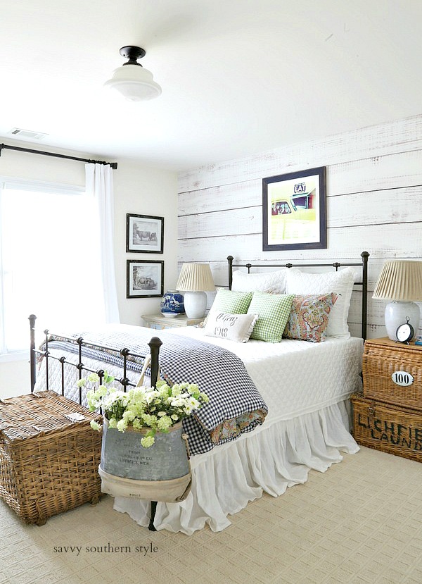 The faux barnwood wall and metal bed frame makes this farmhouse style bedroom a dream space