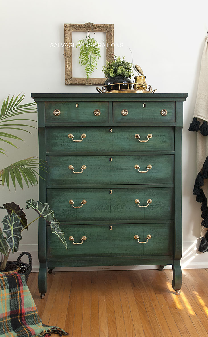 This dark green dresser with gold hardware is unique and adds color to the space.