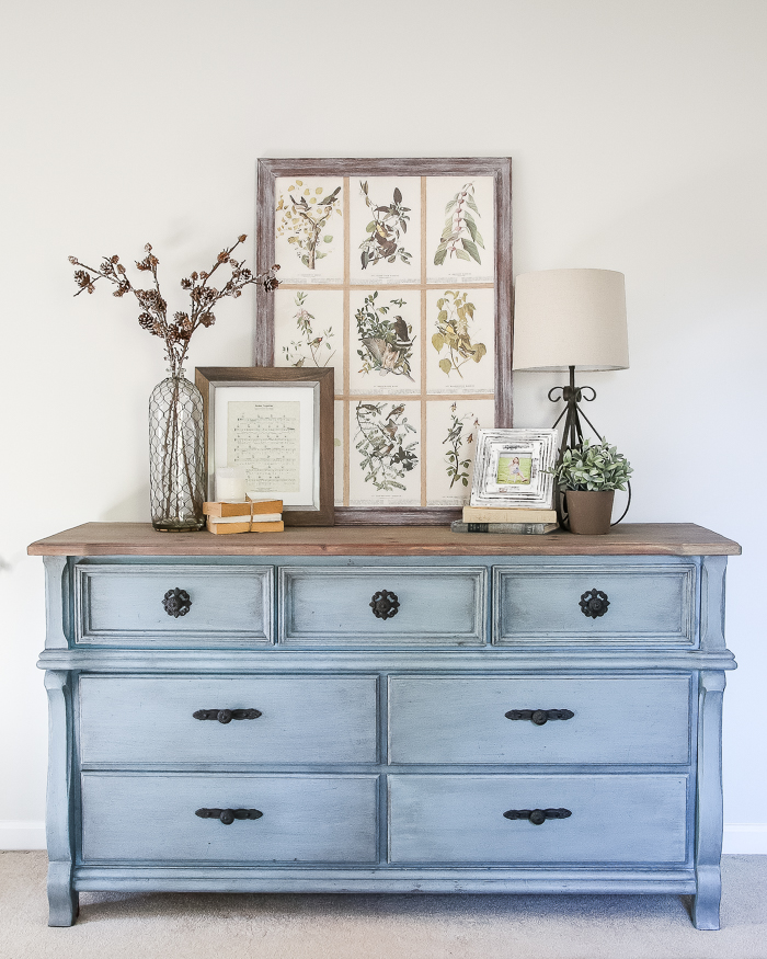 This vintage dresser painted blue with dark hardware and a wooden top is farmhouse and chic.