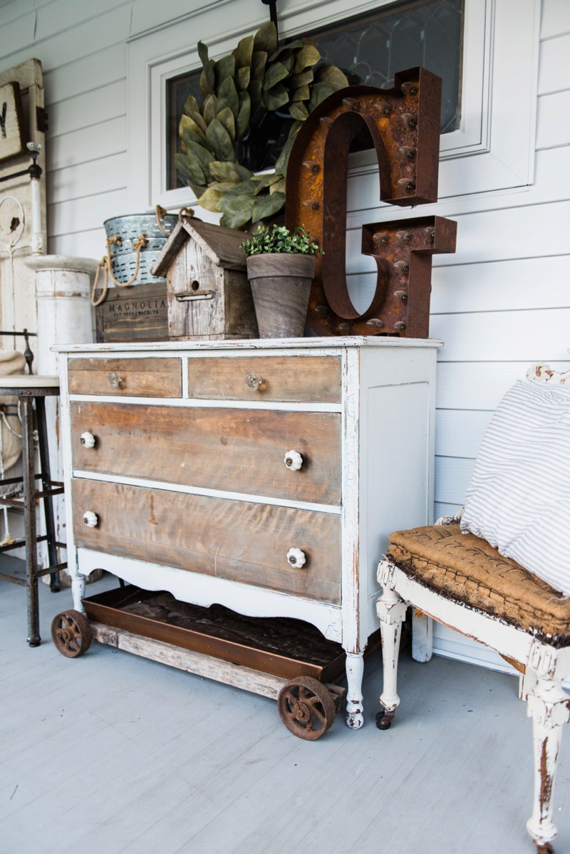This rustic dresser with distressed wood pairs well with the vintage accessories on top.