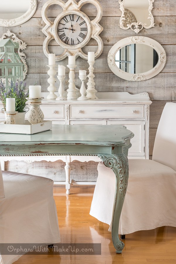 The white vintage dresser in this dining room compliments the hardwood floors.