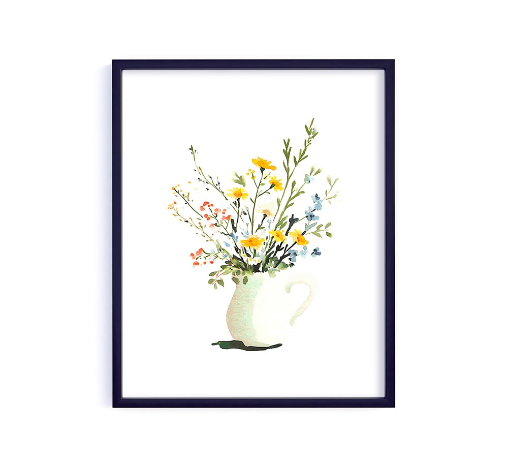 A loose, airy bouquet of wildflowers arranged in a simple pitcher. The mix of soft yellows, blues and greens gives it that effortless cottage garden feel… light, fresh and beautifully relaxed.